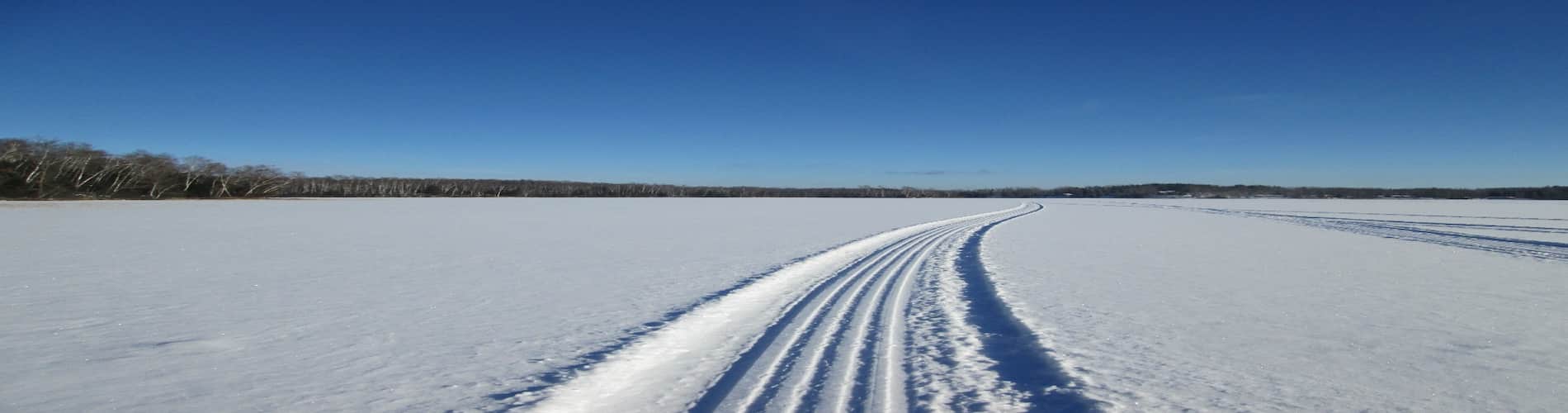 snowmobile-tracks-across-snow-covered-frozen-lake